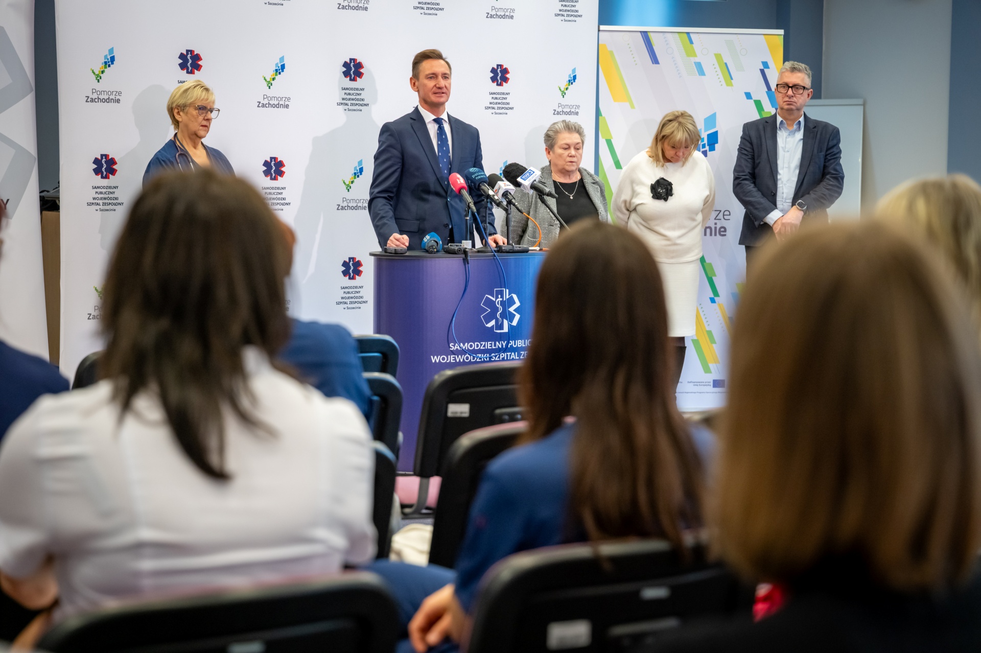 Konferencja prasowa w SPWSZ w Zdunowie - od lewej stoją na tle ścianki z logotypami szpitala i Pomorza Zachodniego - lek. Iwona Witkiewicz, marszałek Olgierd Geblewicz, dyrektor szpitala Małgorzata Usielska i dyrektor WUP Kinga Jacewicz